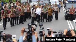 Indonesian President Joko Widodo, center, in white shirt, visits the site of a bomb blast at Thamrin business district in Jakarta, Jan. 14, 2016.