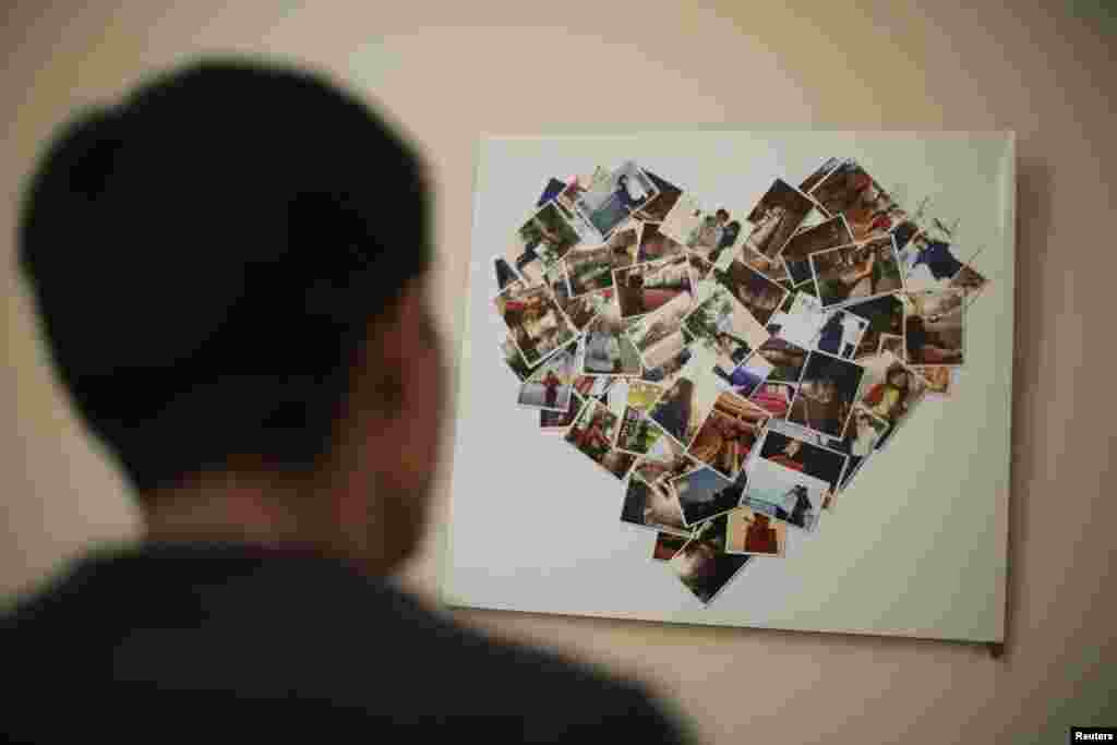 Zhang Zhiliang, 27-year-old Tianjin resident, looks at a board covered with pictures of his fiancee Li Jie, a passenger on board the missing Malaysia Airlines MH370, at their leased apartment in Tianjin, April 5, 2014.