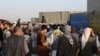 Hundreds of people gather near an evacuation control checkpoint during ongoing evacuations at Hamid Karzai International Airport, in Kabul, Afghanistan, Aug. 25, 2021.
