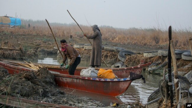 Fishermen prepare to head out into the Chibayish marshes of southern Iraq, in Dhi Qar province, Iraq, Nov. 19, 2022.