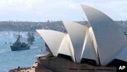 FILE - The Opera House is seen as Australian warships from front, HMAS Sydney, Darwin and Perth enter the harbor in Sydney, Australia, during the International Fleet review, Oct. 4, 2013. 