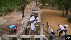 FILE —Residents in Machakos County, Kenya, construct a sand dam on February 29, 2024. Building sand dams, a structure for harvesting water from seasonal rivers, helps minimize water loss through evaporation and recharges groundwater. 