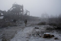 FILE - A Ukrainian soldier passes by a destroyed Butovka coal mine as he approaches a frontline position in the town of Avdiivka in the Donetsk region, Nov. 9, 2019.