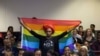 An activist holds up a rainbow flag to celebrate inside Botswana High Court in Gaborone on June 11, 2019. Botswana's Court ruled on June 11 in favour of decriminalising homosexuality, handing down a landmark verdict greeted with joy by gay rights…