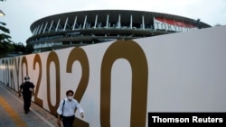 2020 도쿄 올림픽 개막식이 열릴 국립경기장 앞을 7일 신종 코로나바이러스 예방 마스크를 쓴 행인이 지나고 있다.