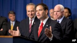 El senador Marco Rubio habla en la rueda de prensa en el Capitolio flanqueado por Chuck Schumer (a su derecha) y John McCain.