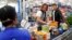 Dos estadounidenses aportan al programa Outnumber Hunger, que ayuda con comida a personas necesitadas.