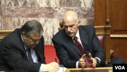 Menteri Keuangan Yunani Evangelos Venizelos (kiri) dan PM George Papandreou saat memberikan keterangan di depan parlemen Yunani di Athena (30/6).