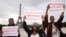 Women hold placards which read, "Bring back our girls", during a demonstration near the Eiffel Tower in Paris, May 13, 2014.