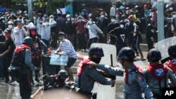 Protesters run after police fire warning-shots and use water cannons to disperse them during a protest in Mandalay, Myanmar on Feb. 9, 2021. 