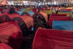 FILE - Migrants set up tents on the Republic square to draw attention to their living conditions and to demand accommodation, in Paris, France, March 25, 2021.