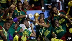 Cameroon players celebrate with the trophy after winning the African Cup of Nations final soccer match between Egypt and Cameroon at the Stade de l'Amitie, in Libreville, Gabon, Sunday, Feb. 5, 2017. Cameroon won 2-1