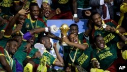 Cameroon players celebrate with the trophy after winning the African Cup of Nations final soccer match between Egypt and Cameroon at the Stade de l'Amitie, in Libreville, Gabon, Sunday, Feb. 5, 2017. Cameroon won 2-1.