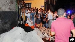 People react after an explosion in Gaziantep, southeastern Turkey, Aug. 21, 2016. Gaziantep province Gov. Ali Yerlikaya said the deadly blast, during a wedding near the border with Syria, was a terror attack. 