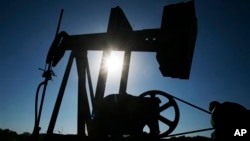 An oil well pumps under the summer sun in a field near Rantoul, Kan., Friday, July 1, 2011. (AP Photo/Orlin Wagner)