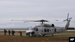 FILE - Japanese Self Defense Forces personnel disembark from a SH-60J helicopter during Typhoon Haiyan relief efforts Nov. 23, 2013 at Tacloban city, in central Philippines.