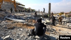 A man sits amid rubble at a site damaged in an Israeli strike on the town of Al-Ain in the Baalbek region, Lebanon, on Nov. 6, 2024.