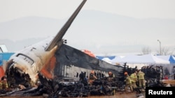 Sejumlah anggota tim tanggap darurat bekerja di lokasi kecelakaan pesawat Jeju Air di Bandara Internasional Muan di Korea Selatan, pada 30 Desember 2024. (Foto: Reuters/Kim Soo-hyeon)