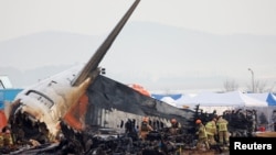 FILE - People work at the site where an aircraft went off the runway and crashed at Muan International Airport, in Muan, South Korea, Dec. 30, 2024.