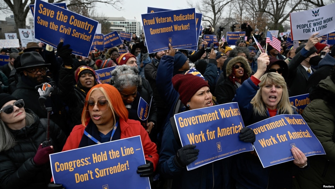 FILE - Labor union activists rally in support of federal workers during a protest in Washington, Feb. 11, 2025. Despite the protests, President Donald Trump signed an executive order Tuesday telling agency leaders to plan for "large-scale reductions in force." 