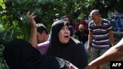 FILE - A woman calls out to her relatives after identifying bodies dumped off a cliff along the highway leading to Marawi on the southern island of Mindanao on May 28, 2017. 