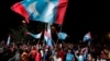 Opposition party supporters cheer and wave their party flags after Mahathir Mohamad claims the opposition party wins the General Election, broadcast on a large screen at a field in Kuala Lumpur, Malaysia, May 9, 2018.