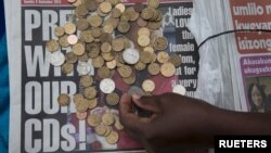 A newspaper vendor counts out change for a customer in Durban, South Africa. 