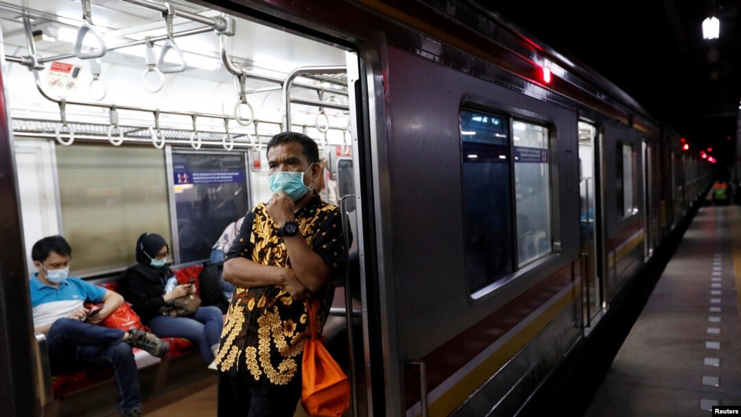 Seorang pria mengenakan masker pelindung wajah di dalam kereta commuter di tengah pemberlakuan Pembatasan Sosial Berskala Besar (PSBB) untuk mencegah penyebaran virus corona di Jakarta, 21 April 2020. (Foto: Reuters)