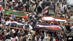 Anti-government protesters carry the coffins of fighters loyal to the tribal leader Sadeq al-Ahmar, who were killed this week during clashes with police, in Sana'a, Yemen, May 27, 2011