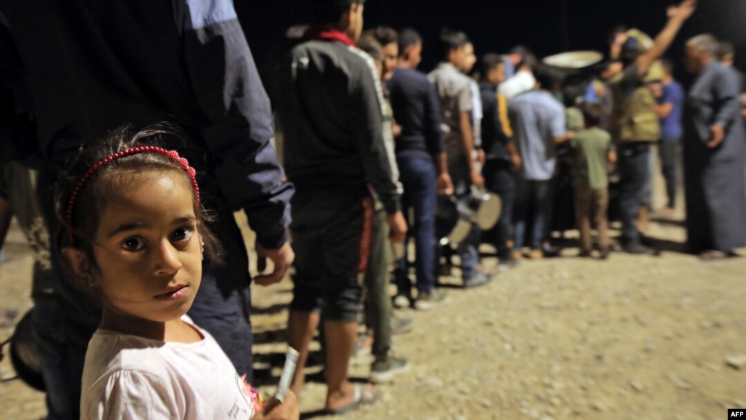FILE - Syrians who fled their homes because of the Turkish military operation in northeastern Syria are pictured upon arriving at the Bardarash camp, near the Kurdish city of Dohuk, in Iraq's autonomous Kurdish region, Oct. 20, 2019.