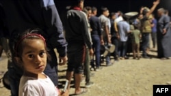 FILE - Syrians who fled their homes because of the Turkish military operation in northeastern Syria are pictured upon arriving at the Bardarash camp, near the Kurdish city of Dohuk, in Iraq's autonomous Kurdish region, Oct. 20, 2019.