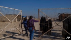 FILE - Members of the Syrian Democratic Forces open a gate of the al-Hol detention camp in northeastern Syria's Hassakeh province, where tens of thousands of mostly women and children linked to the Islamic State group have been living, Jan. 30, 2025.