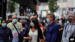 People wearing face masks to protect against the coronavirus queue to buy lottery tickets in downtown Madrid, Spain, Sept. 18, 2020. 