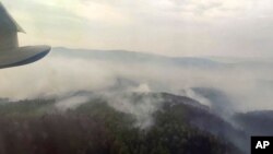 This image taken from video provided by Russian Emergency Ministry, shows a view of a forest fire from a Russian Emergency Ministry multipurpose amphibious aircraft in the Trans-Baikal National Park in Buryatia, southern Siberia, Russia, July 9, 2020.