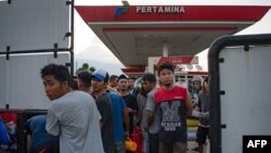 Warga mengantre bensin di SPBU di Palu, Sulawesi Tengah, 29 September 2018, setelah gempa dan tsunami yang menerjang kota itu sehari sebelumnya.