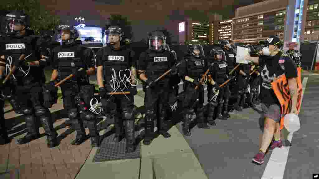 Un manifestant marche devant un cordon de policiers à Charlotte, 22 septembre 2016.