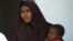Lul Ali Osman, who claimed she was raped by security forces, is seen holding her child at the court house in Mogadishu March 3, 2013.