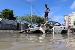 A Somali boy stands on a junk vehicle after heavy rain flooded their neighborhood in Mogadishu, Somalia, Oct. 21, 2019.