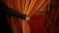 FILE - A security agent opens a curtain covering the entrance of a main hall inside the Great Hall of the People where sessions of the National People's Congress and the Chinese People's Political Consultative Conference take place, in Beijing, China, March 6, 2016. 