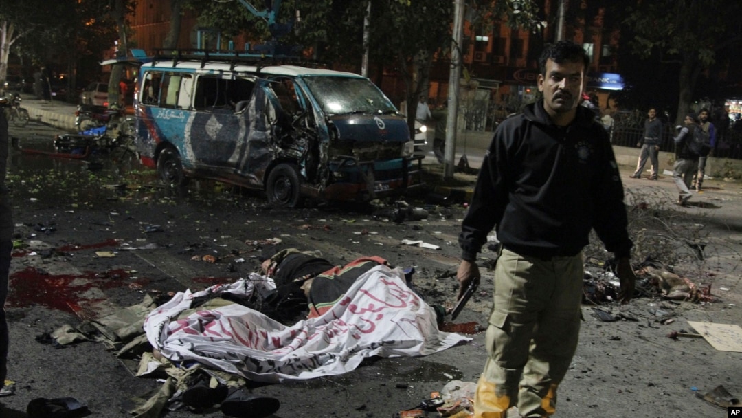 Polisi berjaga-jaga di lokasi pemboman maut di Lahore, Pakistan (13/2). (AP/K.M. Chaudhry)