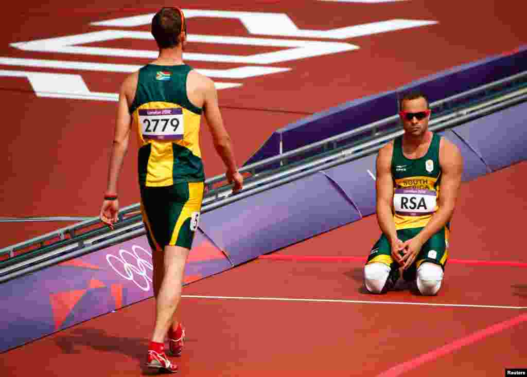 South Africa's Oscar Pistorius (R) and Willem de Beer after their team did not finish in the men's 4x400m relay round 1 heat.