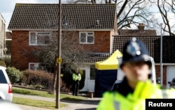 FILE - Police officers stand guard outside the home of Sergei Skripal in Salisbury, Britain, March 8, 2018.