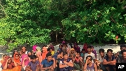 FILE - Rohingya sits on a beach at Rawi island in Satun province Southern of Thailand Tuesday, June 11, 2019. Thai officials say they have discovered 65 ethnic Rohingya Muslim refugees who were shipwrecked and stranded in southern Thailand.