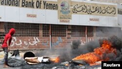 Protesters block a street with burning tires after the Yemeni rial plunged against foreign currencies, in Aden, Yemen, Sept. 2, 2018. 