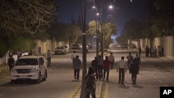 In this photo made on a government-organized tour, residents gather in the neighborhood near the scene of a NATO missile attack in Tripoli, April 30, 2011