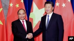 FILE - Chinese President Xi Jinping (right) poses with Vietnamese Prime Minister Nguyen Xuan Phuc prior to a meeting at Great Hall of the People in Beijing, Sept.13, 2016.