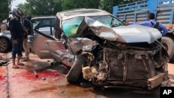 In this photo provided by Cambodia National Police, Cambodia's Prince Norodom Ranariddh's mangled car sits on the side of a road after a collision with another vehicle outside Sihanoukville, Cambodia, Sunday, June 17, 2018. Ranariddh has been seriously injured in the road crash that killed his wife and injured at least seven other people early Sunday. (Cambodia National Police via AP)