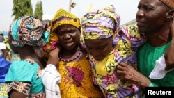 FILE - One of the newly released 82 Chibok school girls embraces her parents as she reunites with her family in Abuja, Nigeria, May 20, 2017. 