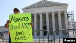El reverendo Patrick Mahoney, director de la Coalición de Defensa Cristiana sostiene un cartel que dice "Abusadores no deben poseer armas" después de que la Corte Suprema rechazara un desafío a una ley federal sobre violencia doméstica, el 21 de junio de 2024, en Washington.