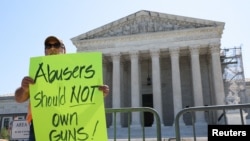 21일 미국 연방대법원에서 가정폭력 전력이 있는 사람에게 총기소지를 금지한 것은 정당하다는 판결이 내려진 후, 패트릭 마호니 목사가 판결을 지지하는 팻말을 들고 있다.